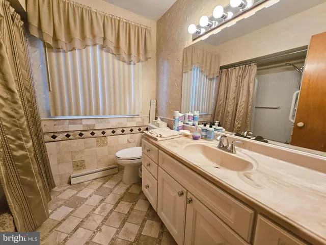a bathroom with a double vanity sink mirror and toilet