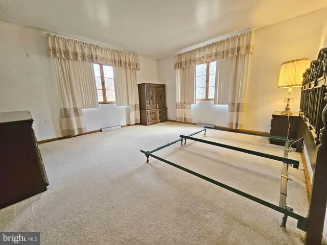 a living room with a couch and a dresser next to a window