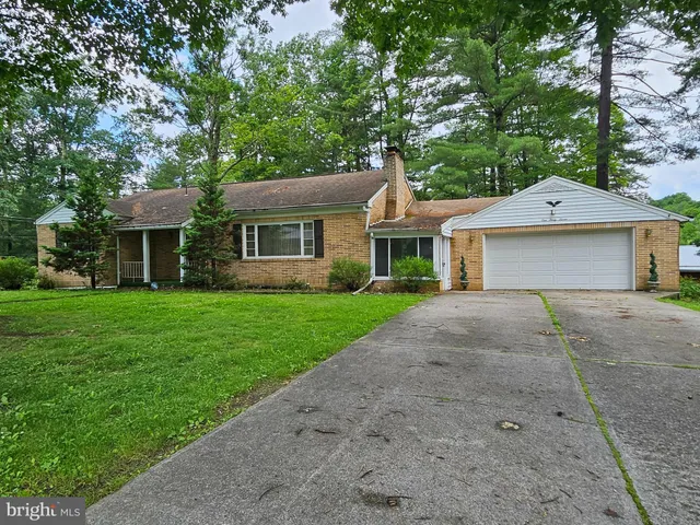 a front view of a house with a yard and trees