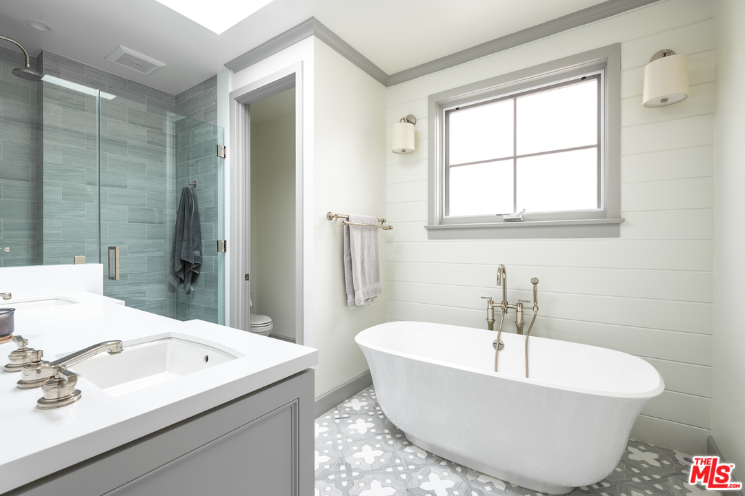 703 Bayview Drive Manhattan Beach, CA 90266 - Photo 12 of 30 a bathroom with a white tub a sink and a window