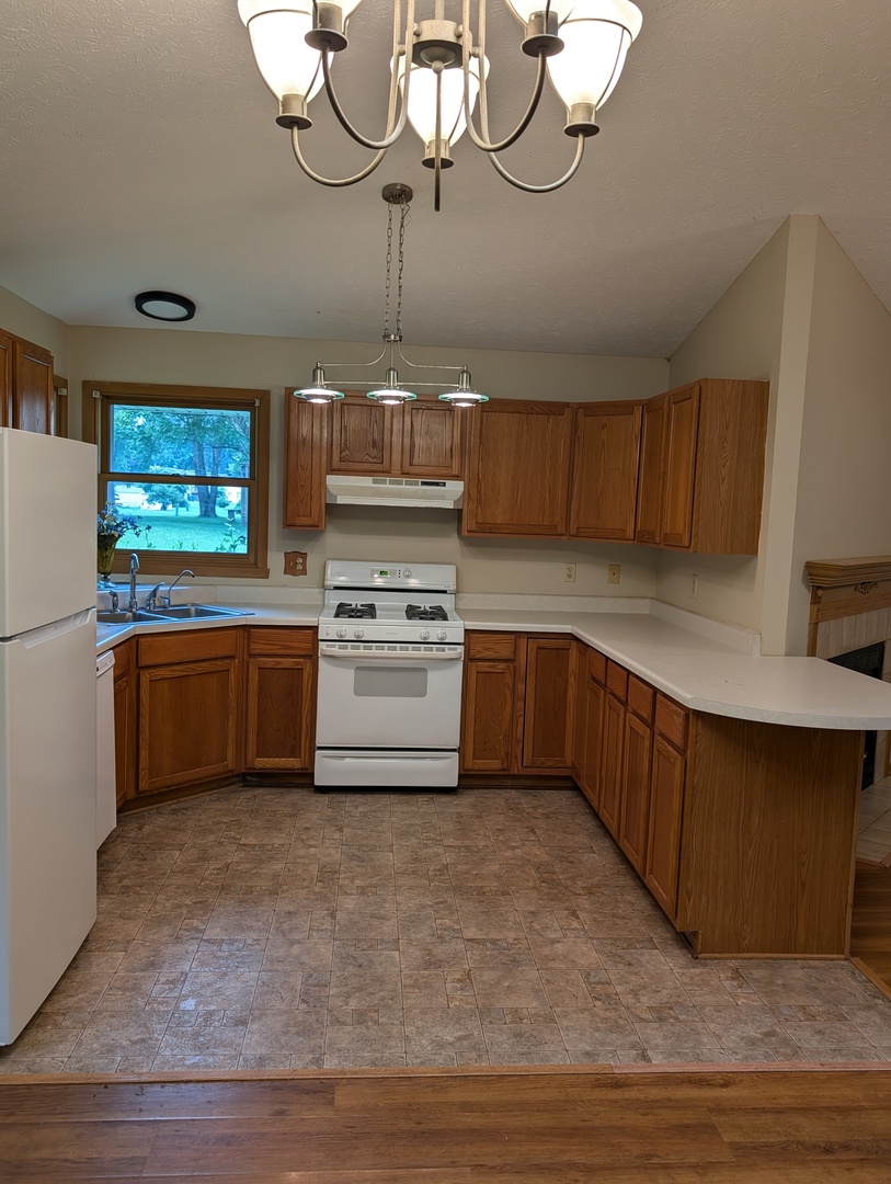 430 Pembroke Road Southwest Poplar Grove, IL 61065 - Photo 3 of 20 a kitchen with stainless steel appliances a stove a sink cabinets and a chandelier