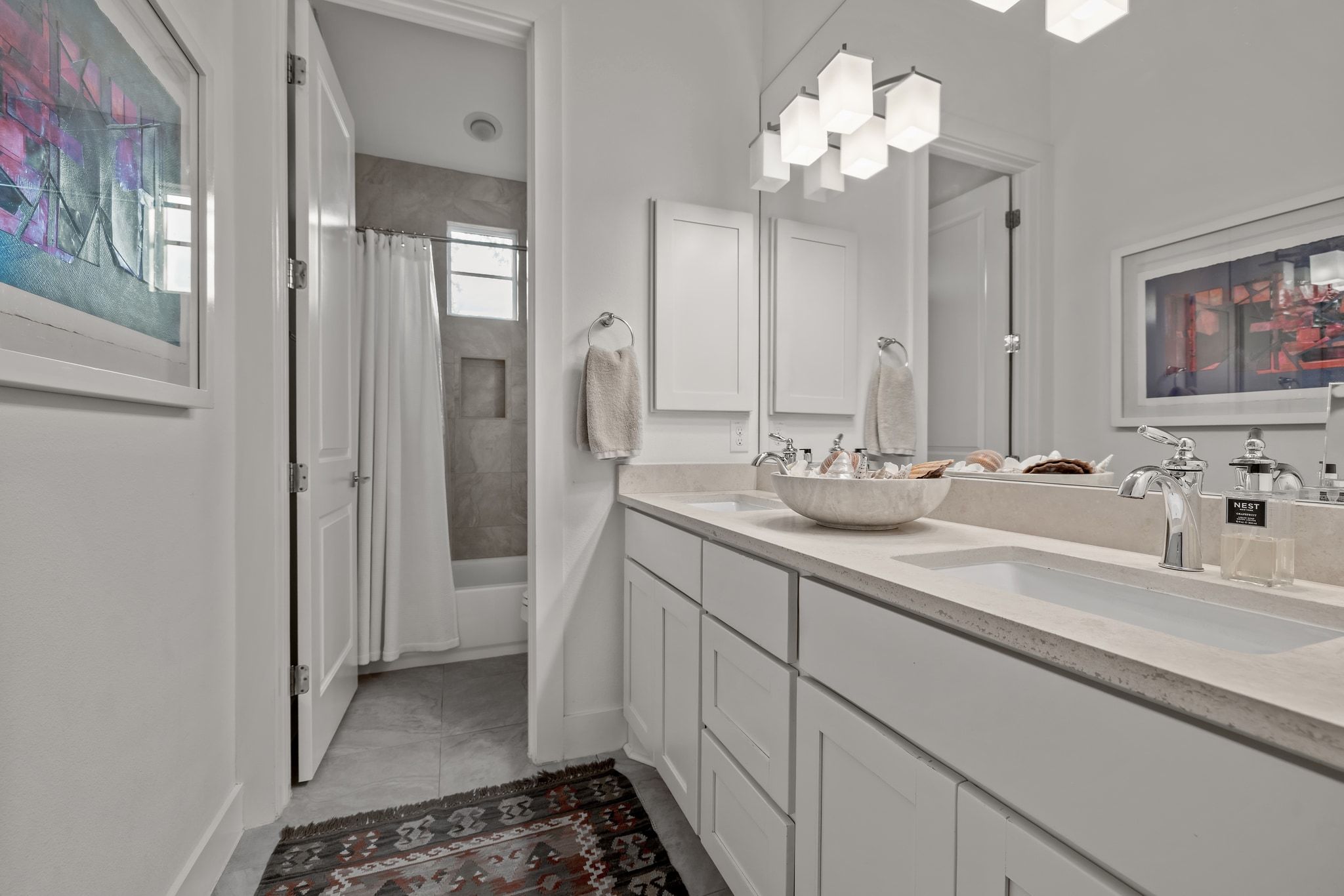 4720 Rockcliff Road, Unit 1 Austin, TX 78746 - Photo 29 of 39 Dual vanity sinks with modern fixtures complement the spacious bathroom, featuring a tiled shower and window.
