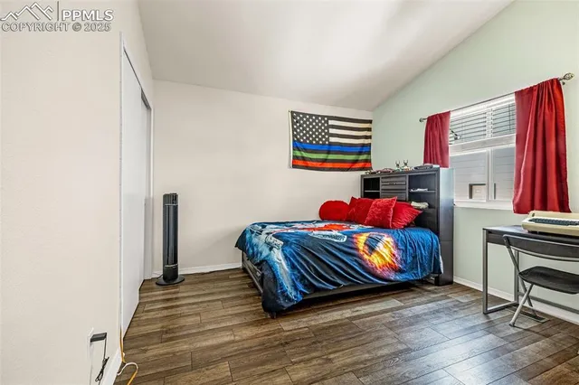 a bedroom with a bed and wooden floor