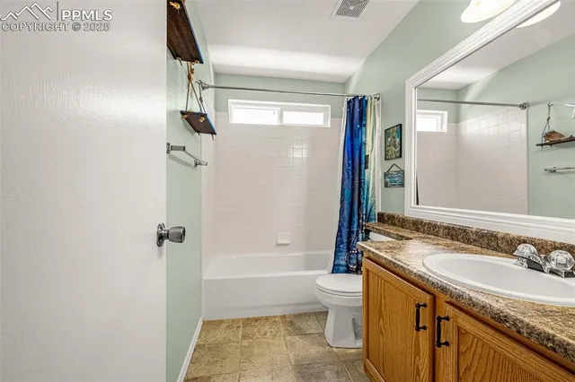 a bathroom with a granite countertop sink a toilet a mirror and shower