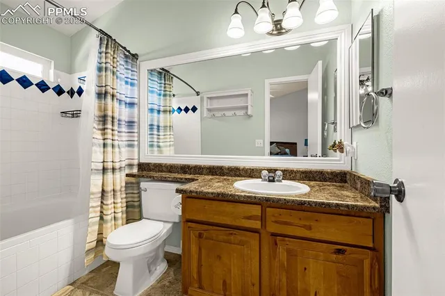 a bathroom with a granite countertop toilet sink and mirror