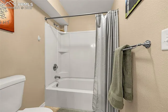a bathroom with a shower a toilet and a tub