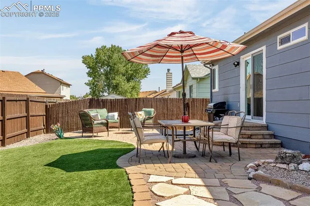 a view of a patio with a table and chairs under an umbrella