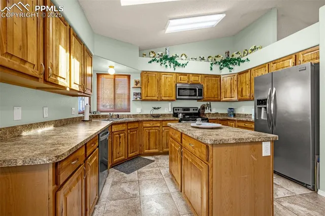 a kitchen with stainless steel appliances granite countertop a sink a stove and a refrigerator