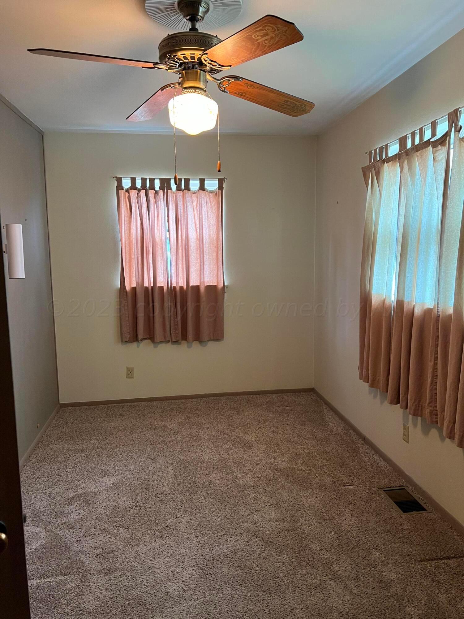 6012 Garden Lane Amarillo, TX 79106 - Photo 6 of 14 an empty room with windows and fan