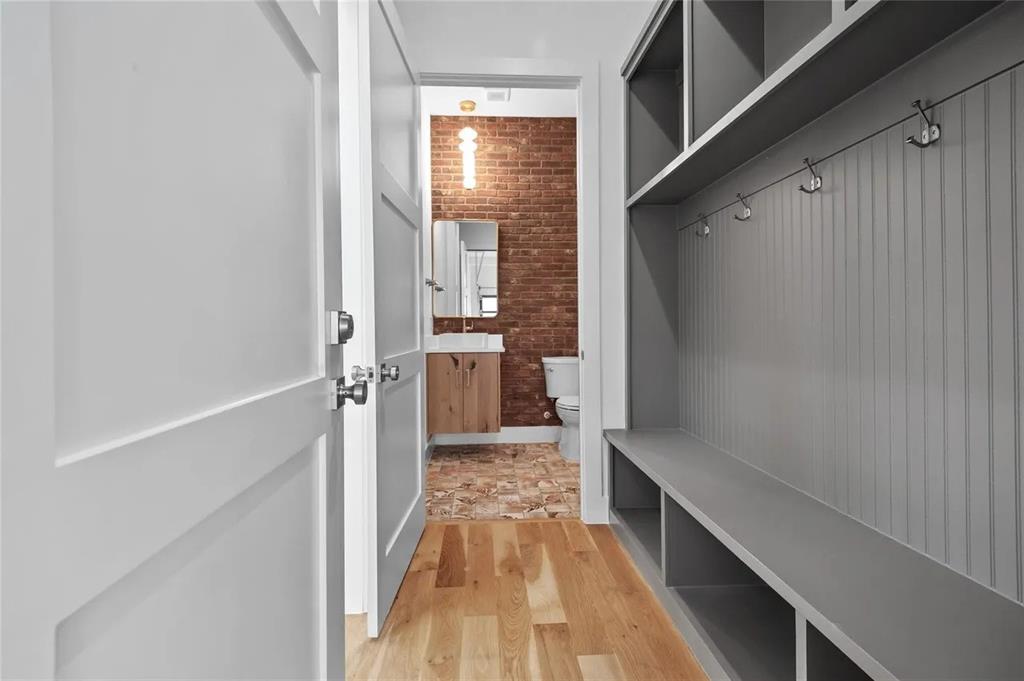 309 Kaye Street Coppell, TX 75019 - Photo 26 of 36 Mudroom featuring built-in gray cabinetry with bench seating, wall hooks, and overhead storage