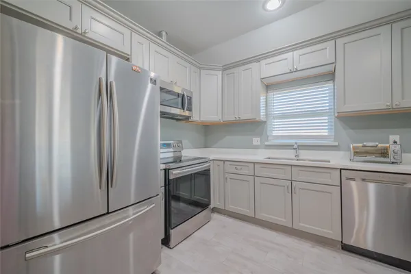 a kitchen with stainless steel appliances granite countertop a refrigerator sink and cabinets