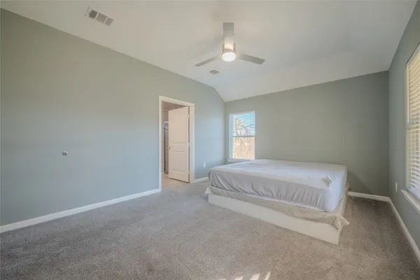 a spacious bedroom with a bed and a chandelier