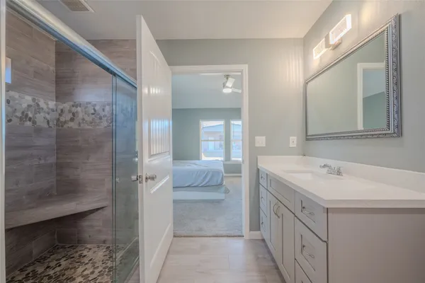 a spacious bathroom with a shower sink and mirror