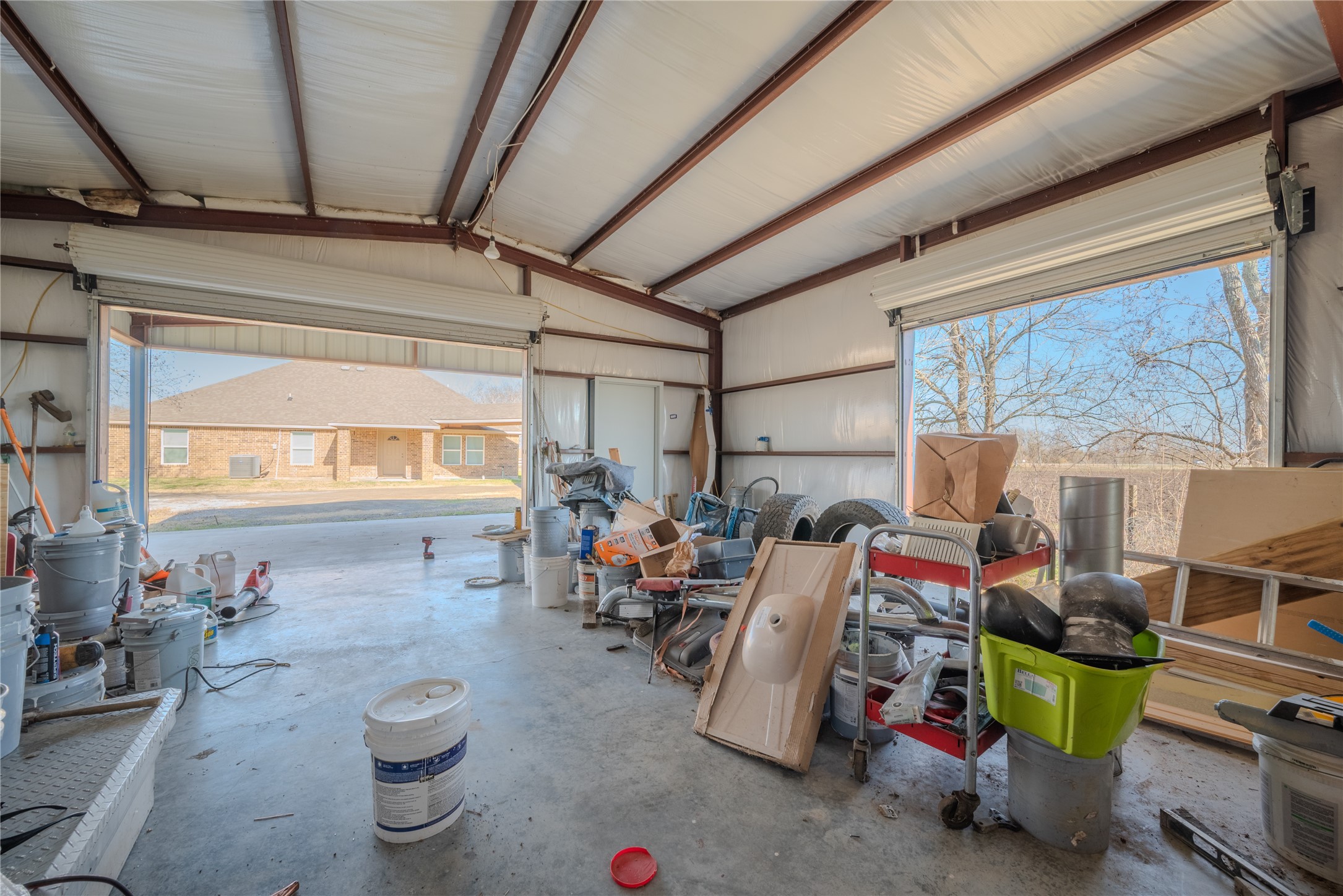 4340 Highway 60 Wharton, TX 77488 - Photo 40 of 49 Massive doors and large windows flood this 1,375 sq ft workshop with light, providing a versatile canvas for any ambitious project.