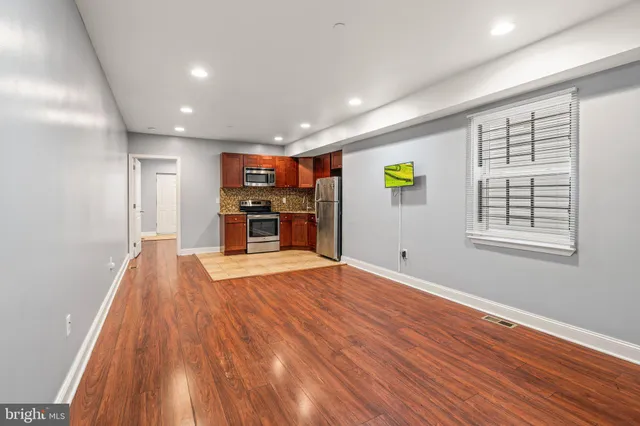 an empty room with wooden floor and window