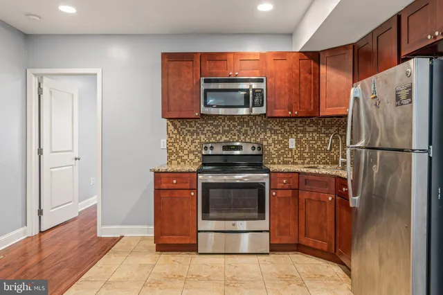 a kitchen with stainless steel appliances granite countertop a refrigerator stove and sink