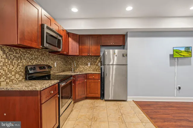 a kitchen with stainless steel appliances granite countertop a refrigerator stove and microwave