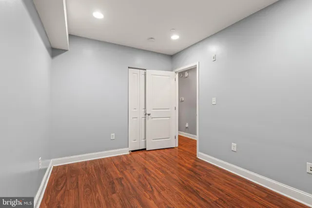 a view of an empty room with wooden floor