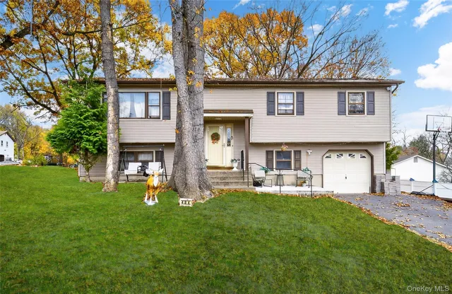 a front view of a house with garden and trees