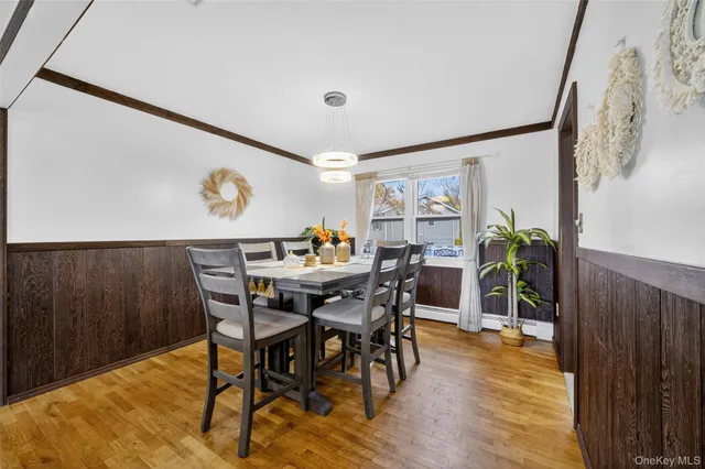 a view of a dining room and kitchen with furniture window and wooden floor