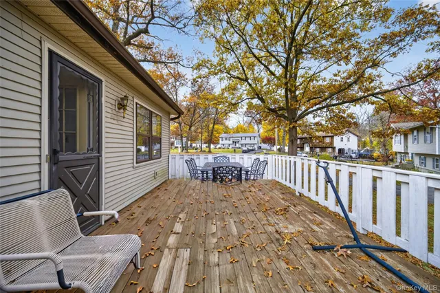 a view of a patio with table and chairs and wooden fence