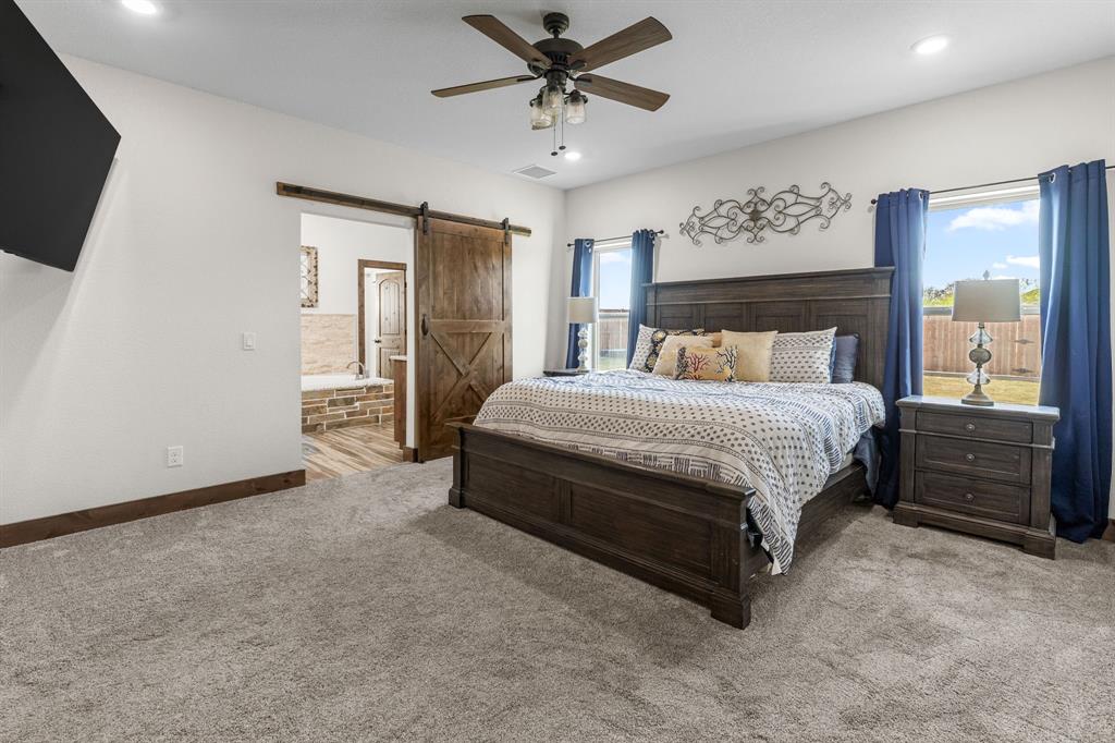515 Sales Road Windthorst, TX 76389 - Photo 15 of 34 a bedroom with a bed a window and a flat screen television