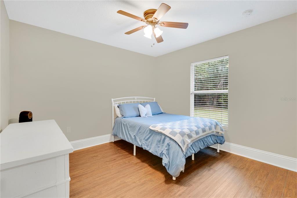 396 North Post Office Road Kenansville, FL 34739 - Photo 13 of 34 a bedroom with a bed and a chandelier