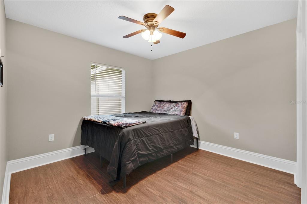 396 North Post Office Road Kenansville, FL 34739 - Photo 17 of 34 a bedroom with a bed and a ceiling fan