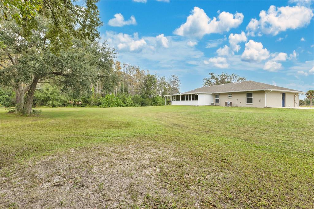396 North Post Office Road Kenansville, FL 34739 - Photo 22 of 34 a view of a house with a big yard