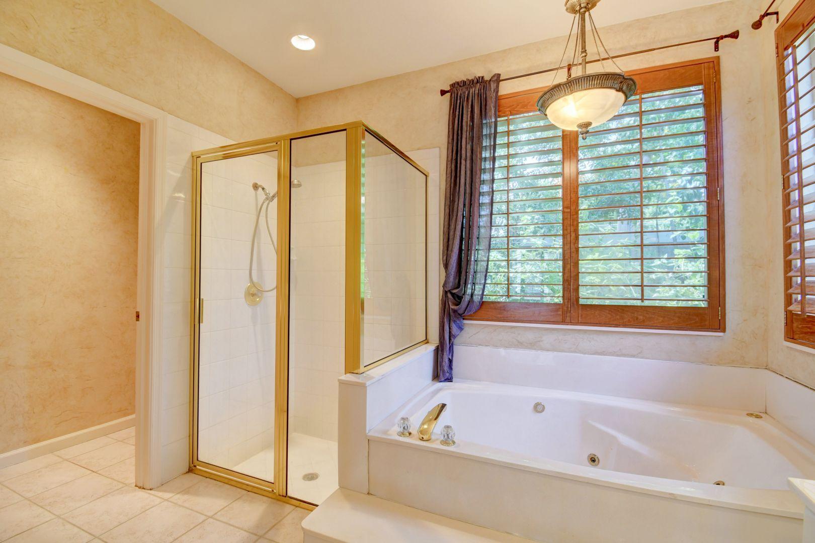 20710 Northwest 29th Avenue Boca Raton, FL 33434 - Photo 29 of 35 a bathroom with a bathtub a shower and a window