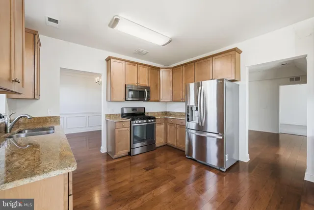 a kitchen with wooden cabinets and stainless steel appliances