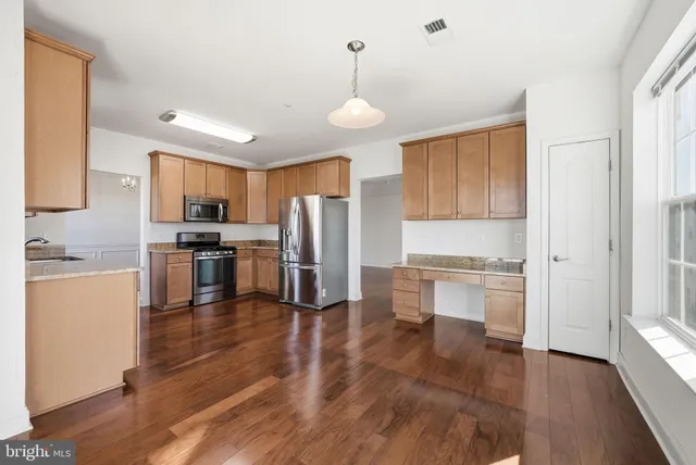 a kitchen with refrigerator cabinets and wooden floor