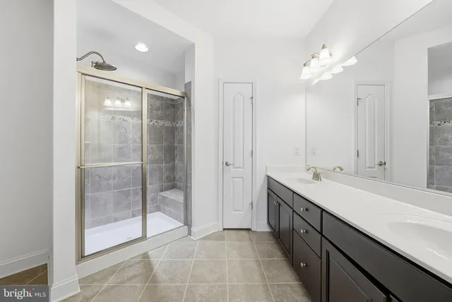 a spacious bathroom with a mirror a shower and vanity