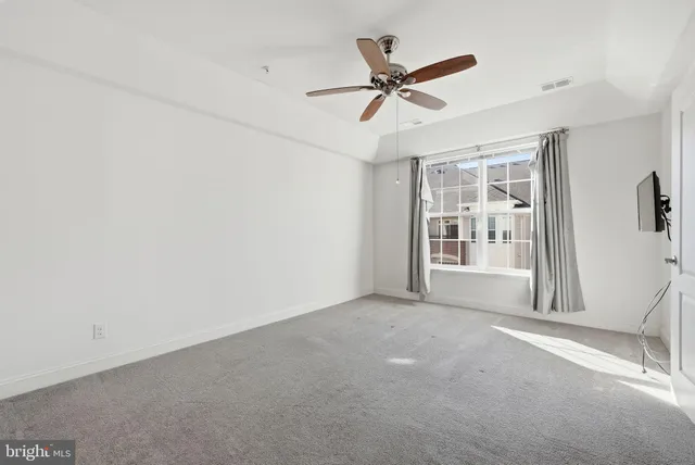 a view of a livingroom with a ceiling fan and window