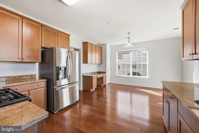 a kitchen with wooden floors and stainless steel appliances
