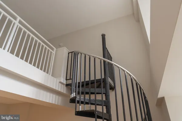 a view of staircase with railing and white walls