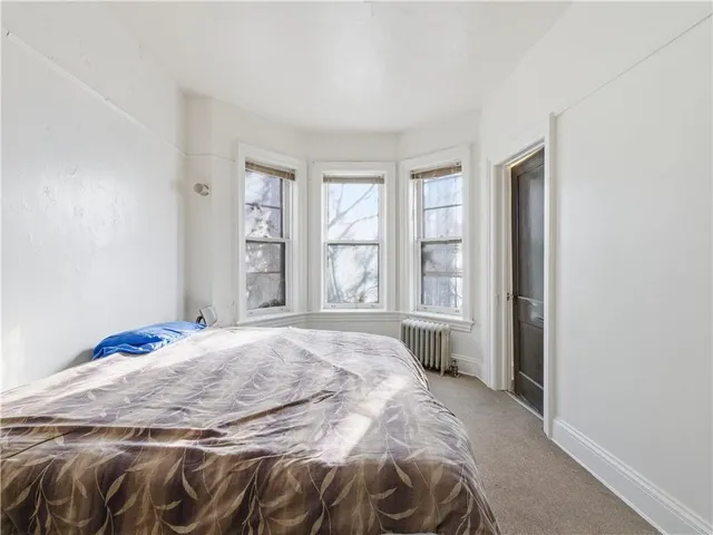 a bed sitting in a bedroom next to a window