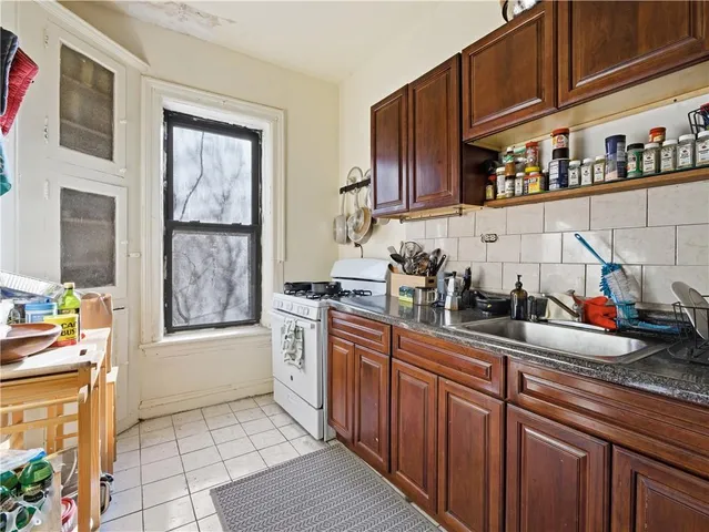 a kitchen with stainless steel appliances granite countertop a sink stove and cabinets