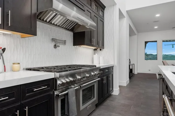 a kitchen with stainless steel appliances a sink dishwasher stove and cabinets