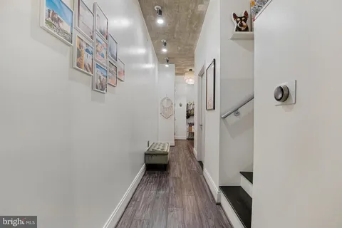 a view of a hallway with wooden floor and staircase