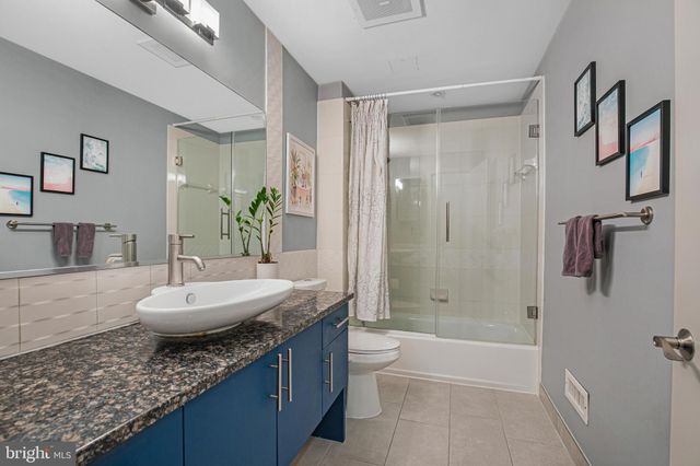 a bathroom with a granite countertop tub sink and mirror
