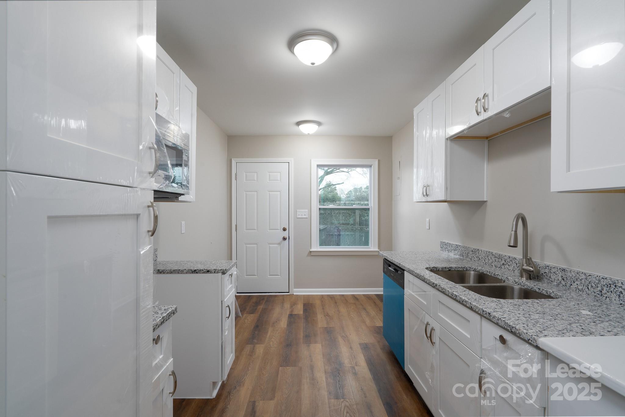 745 Arbor Street Northeast, Unit 5 Concord, NC 28025 - Photo 6 of 20 a kitchen with cabinets and wooden floor