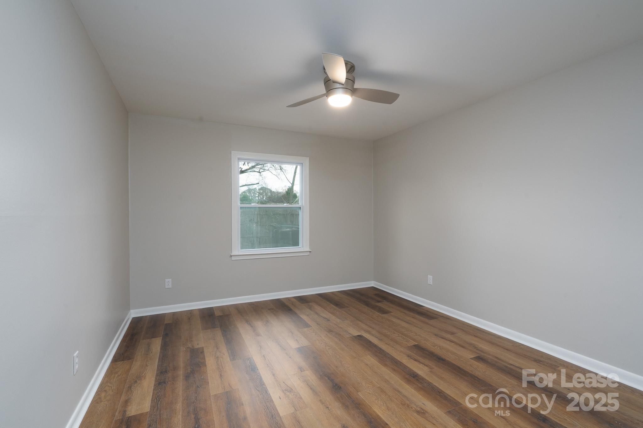 745 Arbor Street Northeast, Unit 5 Concord, NC 28025 - Photo 10 of 20 an empty room with wooden floor and windows