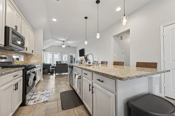 a large kitchen with granite countertop lots of counter space and a sink
