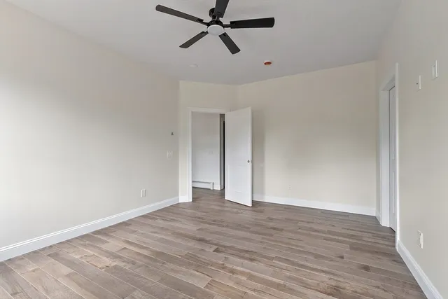 a view of an empty room with wooden floor