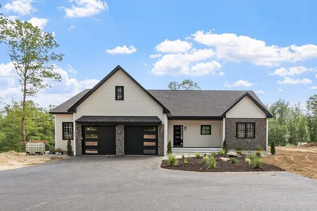 a front view of a house with a garden and trees