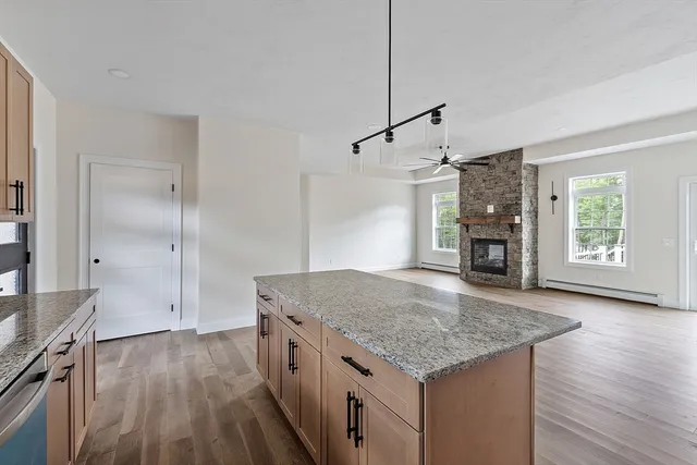 a kitchen with kitchen island a counter top space wooden floor and a ceiling fan