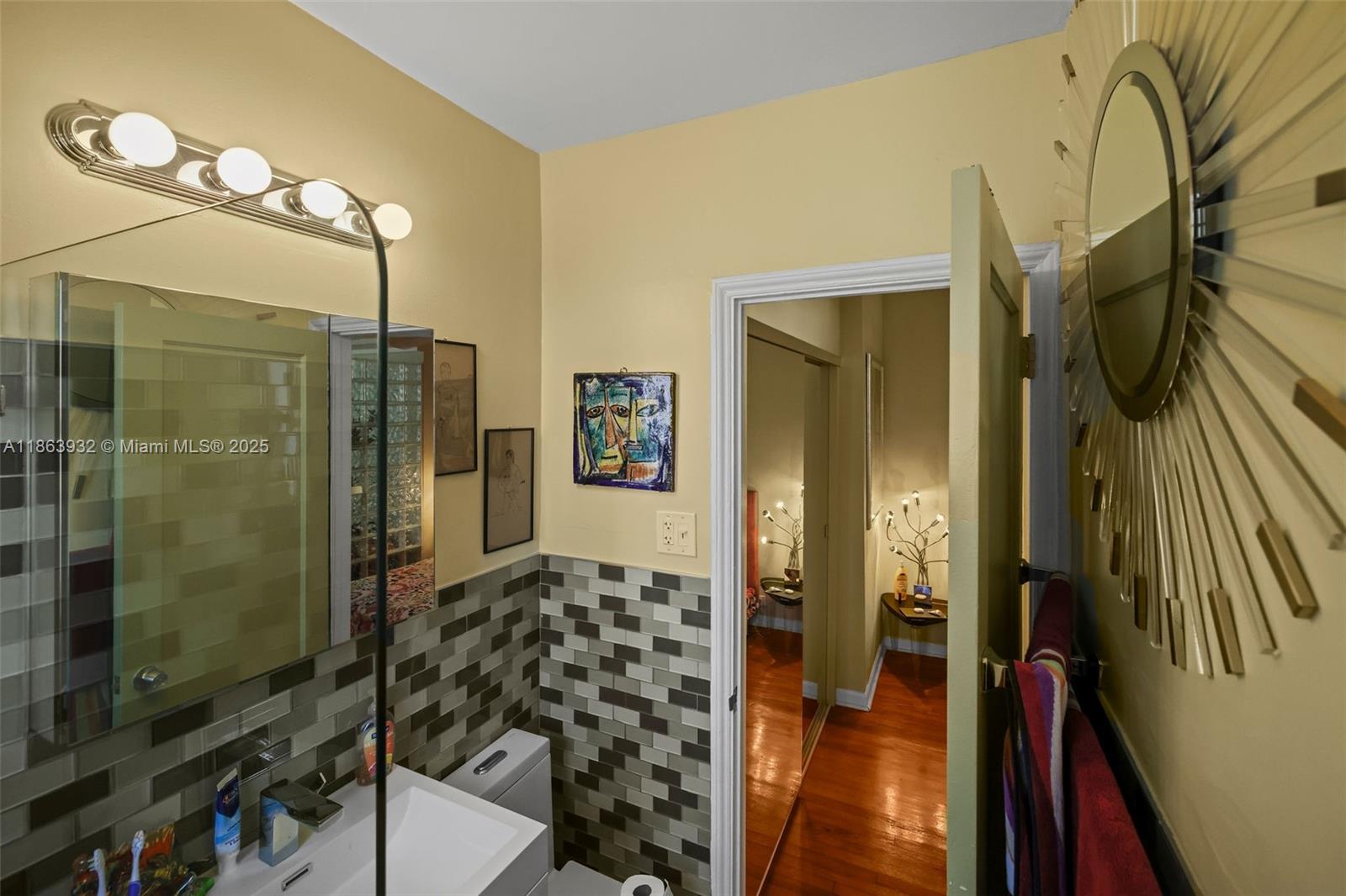 1525 Meridian Avenue, Unit 202 Miami Beach, FL 33139 - Photo 17 of 23 a bathroom with a glass shower door and a glass door