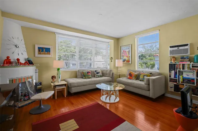 a living room with furniture wooden floor and a large window