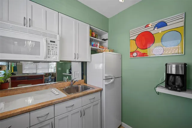a kitchen with stainless steel appliances granite countertop a sink and a microwave